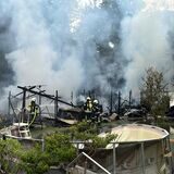 Feuerwehrleute löschen brennende Gartenlauben.