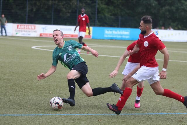 Cappenbergs Torschütze Luis Buschmann fällt nach einem Zusammenstoß mit einem Gegenspieler, Gökhan Karatas (r.) vom TSC Kamen läuft zum Ball.