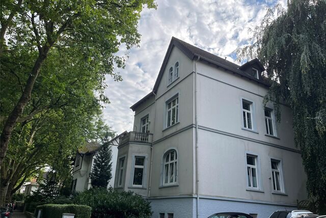 Ein Blick in die Bornekampstraße mit großen Häusern und hohen Bäumen.