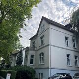 Ein Blick in die Bornekampstraße mit großen Häusern und hohen Bäumen.