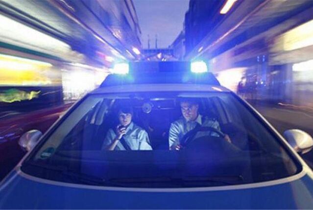 Zwei Beamte in einem Polizeiauto.