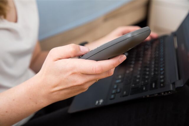 Eine Frau telefoniert mit dem Festnetz-Telefon.