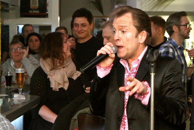 Ein Sänger steht am Tresen einer Kamener Kneipe und singt.