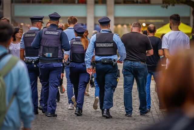 Vier städtische Ordnungskräfte in Uniform auf Streife.