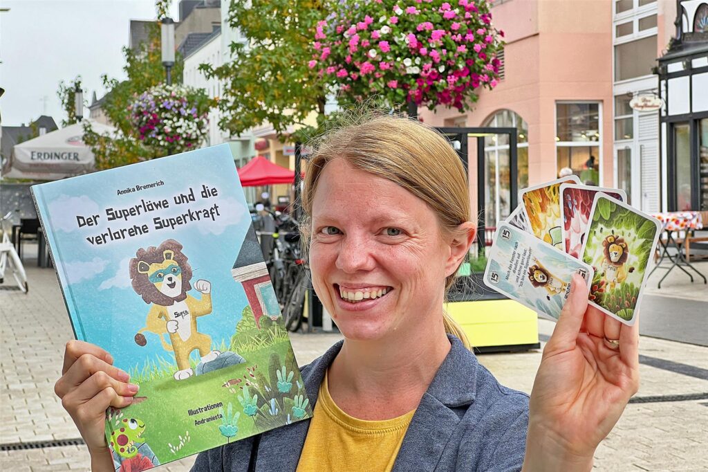 Eine Frau zeigt ein Kinderbuch und ein Spiel für Kinder.