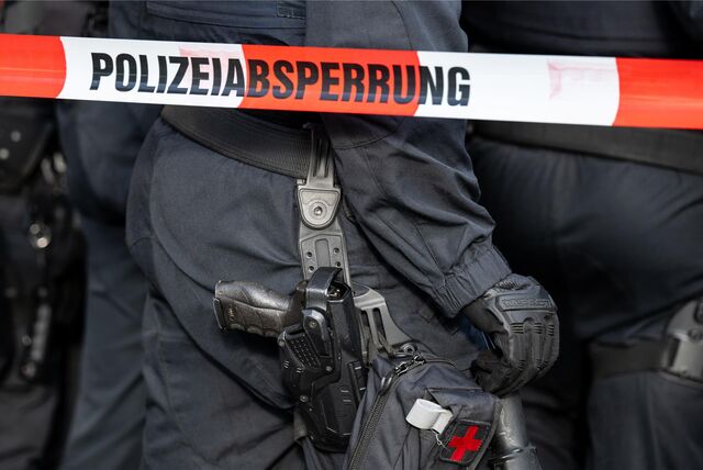 Polizisten hinter einer Absperrung.