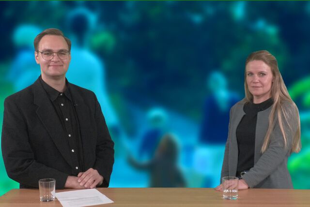 Martin Teichert vom Hellweger Anzeiger und Sina Feige von der Kreisverwaltung stehen an einem Tisch und lächeln in die Kamera.
