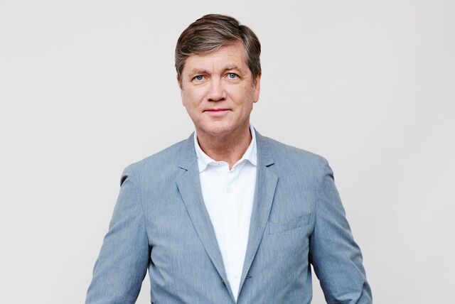 Ein Foto von Autor Peter Prange. Er hat dunkelblondes, volles Haar und trägt eine Kurzhaarfrisur mit Seitenscheitel. Er trägt ein weißes Hemd, ein hellgraues Sakko und schaut frontal in die Kamera.