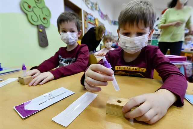 Schüler sitzen mit Mund-Nasen-Schutz im Unterricht in der Grundschule und führen einen Corona-Test durch.