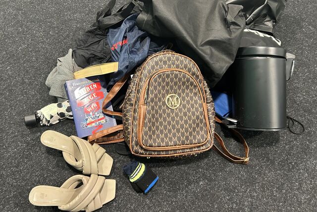 Fundsachenhaufen mit Schuhen, mehreren Taschen und einem Mülleimer