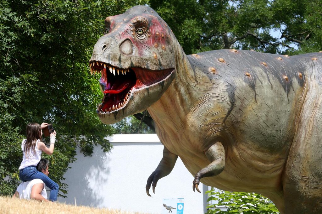 Zwei Personen stehen am Planetarium Bochum vor einer Tyrannosaurus Rex Figur Zwei Personen stehen am Planetarium Bochum vor einer Tyrannosaurus Rex Figur