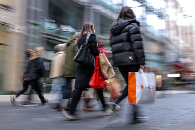 Passanten gehen am verkaufsoffenen Sonntag mit mehreren Einkaufstüten durch die Innenstadt.