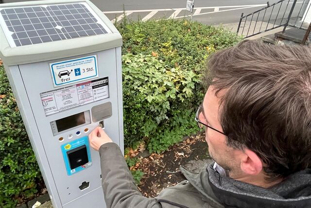 Ein Mann bezahlt an einem Parkautomaten in der Parkautomat Ostring/Wasserstraße,
