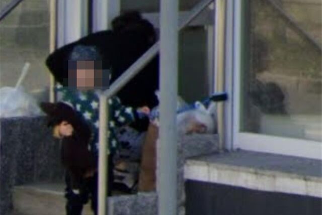 Dieses Bild ist bei Google Street View zu finden. Ein Kind steht an einer Leine vor dem Eingang zu den Räumen, in denen es von der Tagesmutter betreut wird.