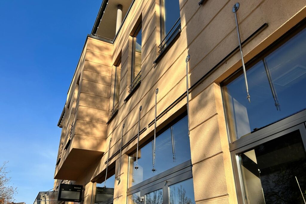 Die Halterungen der Glasdächer an einer Hausfassade an der Haltestelle Die Halterungen der Glasdächer an einer Hausfassade an der Haltestelle