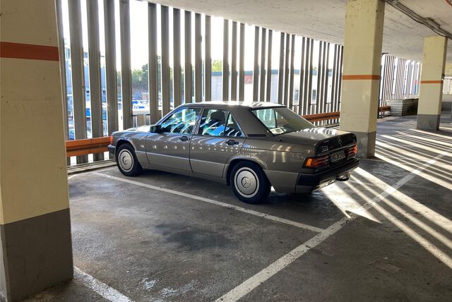 Ein silberner Mercedes steht in einer Parkbucht in einem Parkhaus.