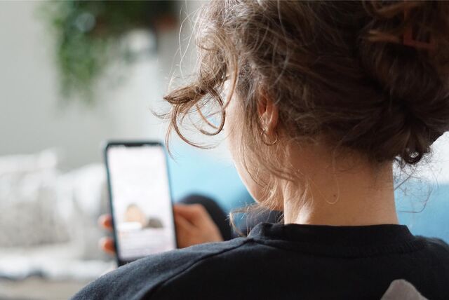 Eine Frau hält ein Smartphone in der Hand.
