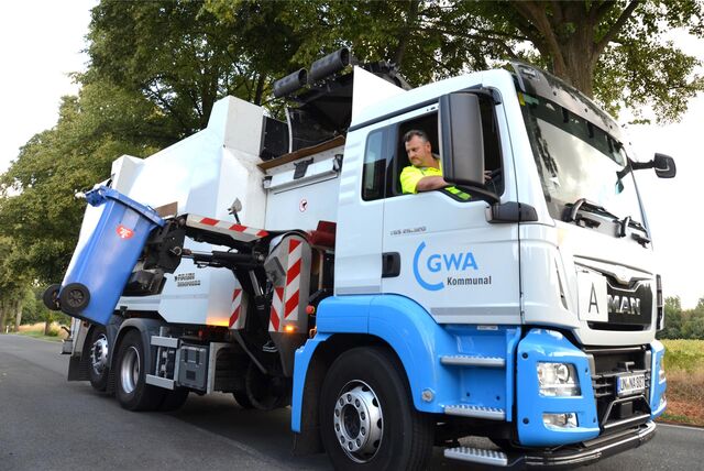 Ein Fahrzeug der GWA Kreis Unna leert eine Papiertonne.