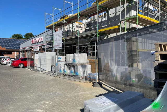 Neben einem Rossmann-Drogeriemarkt entsteht ein Neubau mit Ladenlokal im Erdgeschoss und Wohnungen darüber.