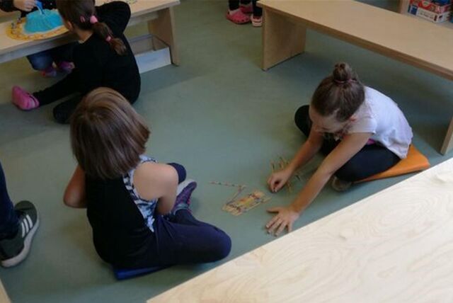 Kinder spielen auf dem Boden.