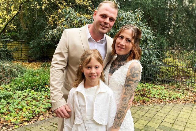 Mandy und Dennis Wenglorz stehen nach ihrem Jawort im Hertener Standesamt mit Tochter Svea (10) vor dem Rathaus.