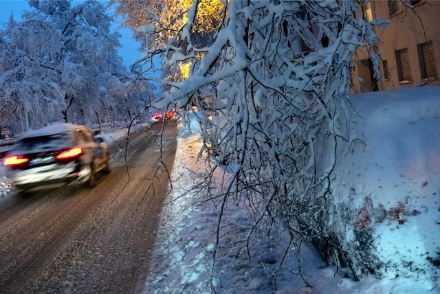 Ein Auto fährt bei Schnee und Eis auf einer Straße.