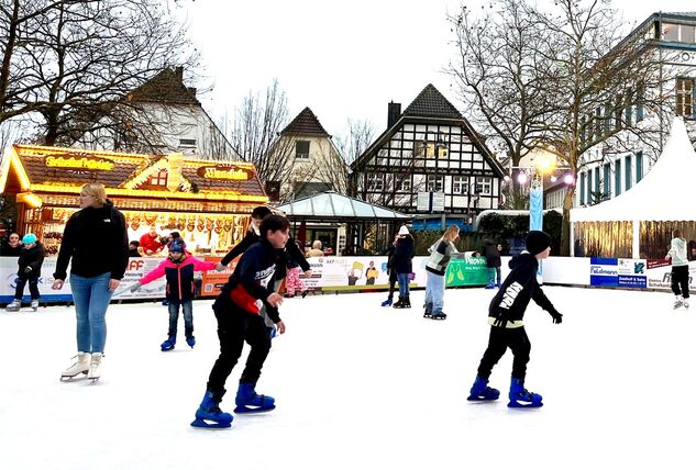 Auf der Eisbahn der Kamener Winterwelt sind Kinder mit Schlittschuhen unterwegs.
