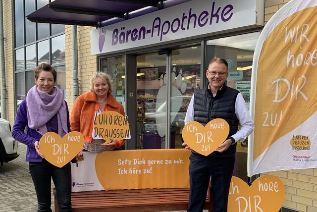 Tanja Adick (links), Inhaberin der Bären-Apotheke, Christine von Fragstein, Initiatorin der Initiative „Zuhören draußen“ und Bürgermeister Thomas Orlowski freuen sich auf die neue Zuhör-Bank an der Bärenapotheke.