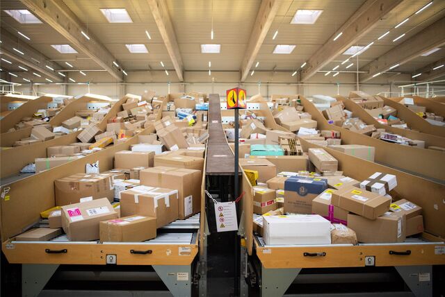 Pakete liegen in einem Paketzentrum der DHL.