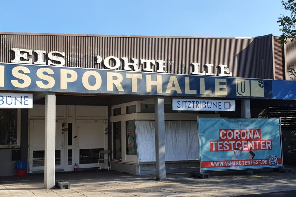 Die inzwischen abgerissene alte Eissporthalle Unna von außen. Unten rechts hängt ein Transparent mit der Aufschrift Die inzwischen abgerissene alte Eissporthalle Unna von außen. Unten rechts hängt ein Transparent mit der Aufschrift