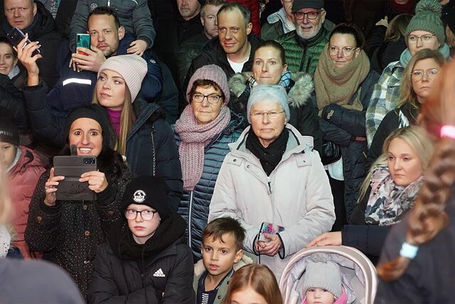 Menschen stehen bei der Eröffnung des Massener Weihnachtsmarktes vor der Bühne.