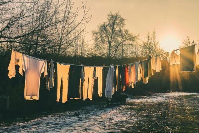 Wäscheleine in einem winterlichen Garten, an der Wäsche hängt.