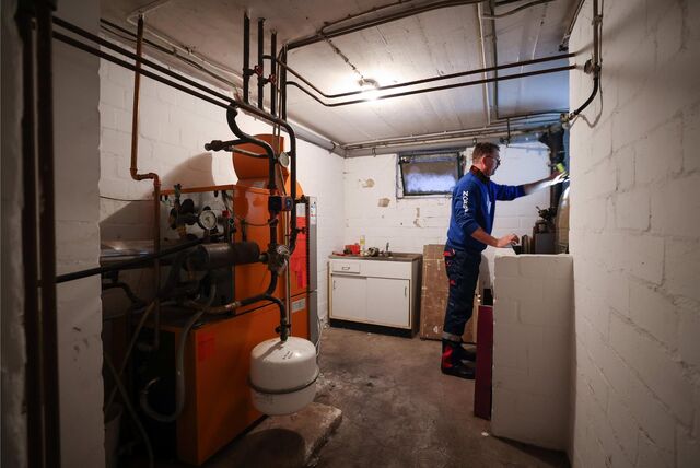 Ein Mitarbeiter eines Diesel- und Heizöl-Unternehmens prüft die beiden Kunststofftanks in einem Heizungskeller bei der Heizöllieferung für die Heizung in einem Einfamilienhaus. (Symbolbild)