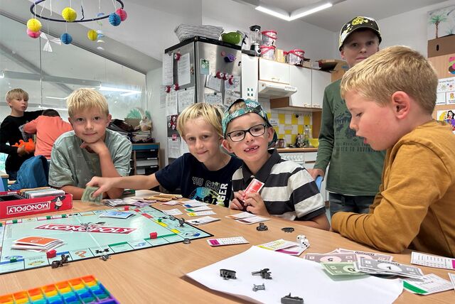 Kinder spielen in einer Offenen Ganztagsschule (OGS) Gesellschaftsspiele.