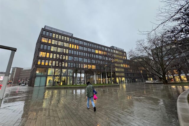 Eine Passantin läuft auf das BIG-Gebäude in Dortmund zu.