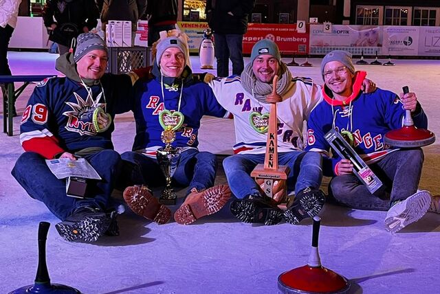 Eine Mannschaft im Eisstockschießen bestehend aus vier Männern sitzt auf der Eisfläche auf der Kamener Winterwelt.