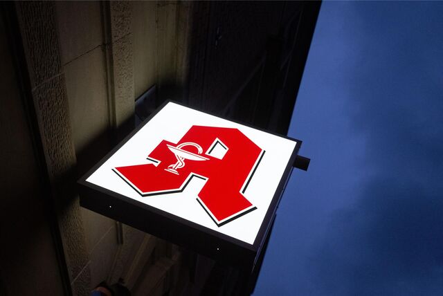 Ein Apothekenschild leuchtet an der Fassade eines Gebäudes in der Innenstadt.