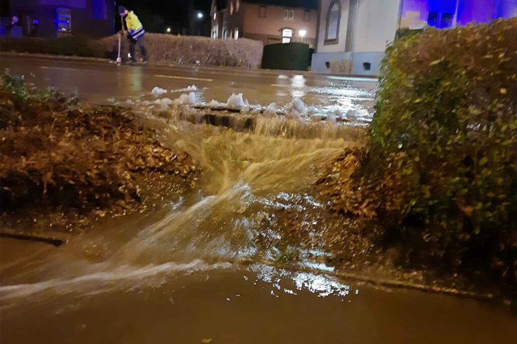 Das Wasser ergießt sich in tiefer liegende Bereiche und bedroht Häuser.