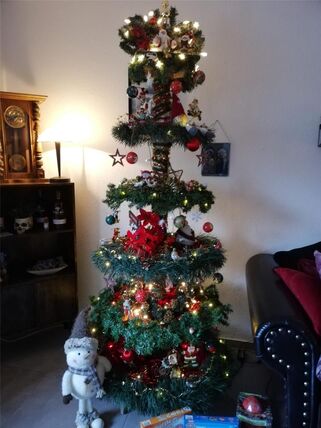 Ein künstlicher Weihnachtsbaum, dessen Baumscheiben als Schenk- und Deko-Ablage dienen.