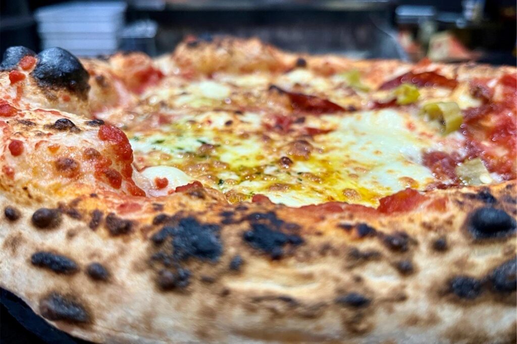 Die dunklen Stellen am breiten Pizzarand sind typisch für eine neapolitanische Pizza. Die dunklen Stellen am breiten Pizzarand sind typisch für eine neapolitanische Pizza.