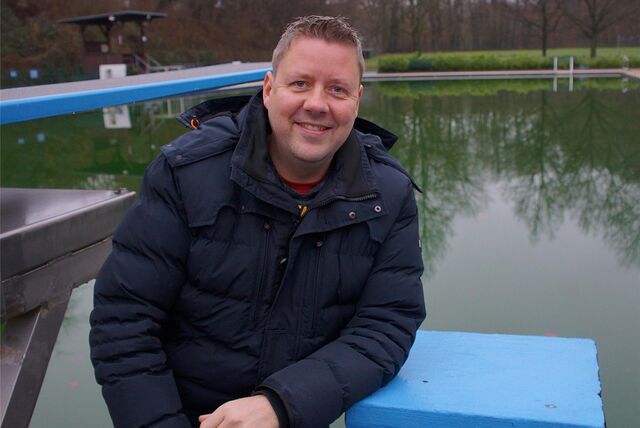 Geschäftsführer Dirk Weise sitzt am Beckenrand im Freibad Dellwig