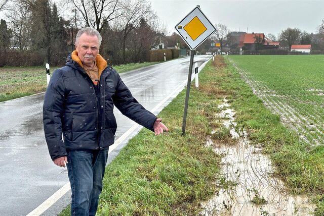 Erhard Wiczoreck steht in Unna am Westhemmerder Weg zwischen Hemmerde und Westhemmerde. Er deutet auf einen Graben, der voll Wasser steht, und das daneben liegende Feld.