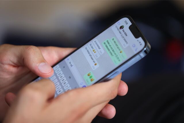 Ein junger Mann tippt auf einem Smartphone eine WhatsApp Nachricht.