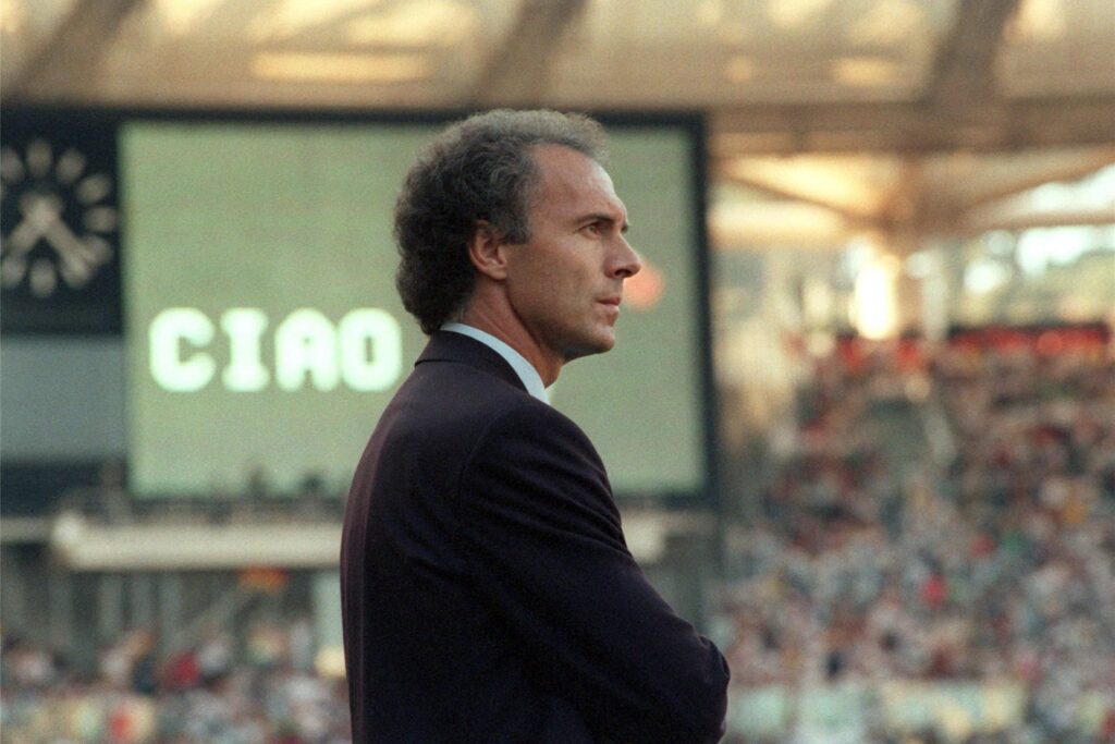 Franz Beckenbauer, damals Bundestrainer, schaut mit ernstem Gesicht auf das Spielfeld des Olympiastadions - die deutsche Nationalelf hatte Argentinien mit 1:0 im WM-Finale besiegt.