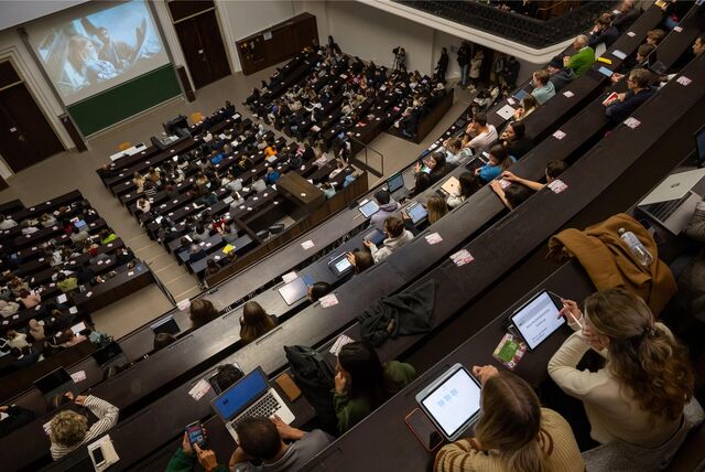 Viele Studenten sitzen in einem Hörsaal.