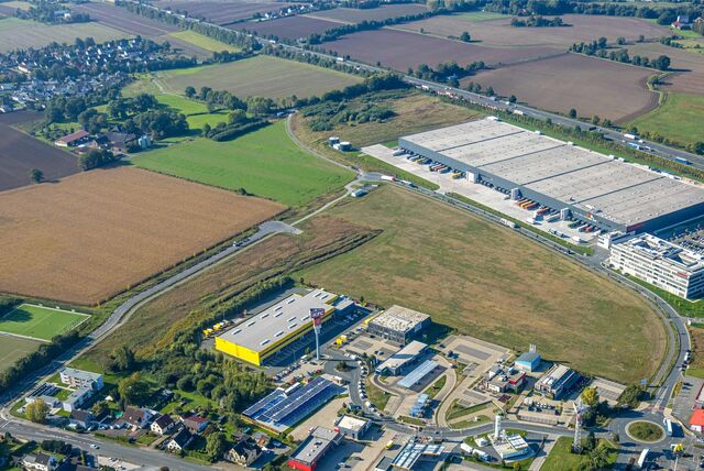 Das Luftbild zeigt das interkommunale Gewerbegebiet Unna-Kamen, rechts im Bild das Woolworth-Lager an der A1, oben links Unna-Afferde