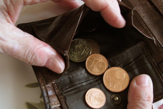 Eine Person sucht Kleingeld aus einem Portemonnaie