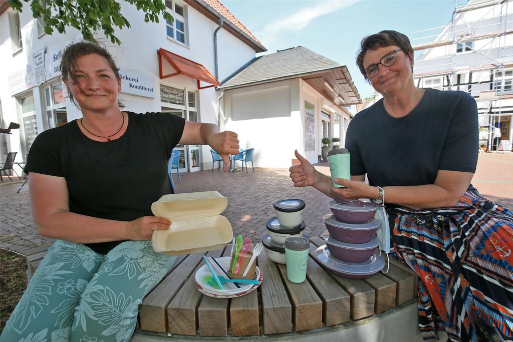 Klimaschutzmanagerin Diane Bruners (l.) und Bürgermeisterin Sabina Müller (r.) sitzen auf einer Bank auf dem Fröndenberger Marktplatz