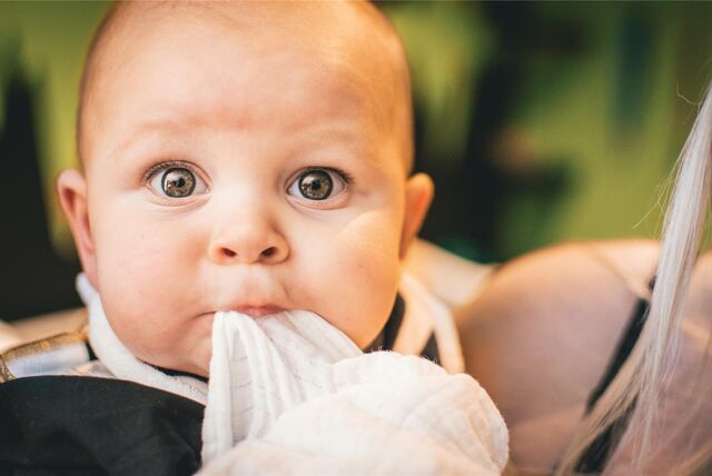 Ein Baby schaut mit weit aufgerissenen Augen in die Kamera.
