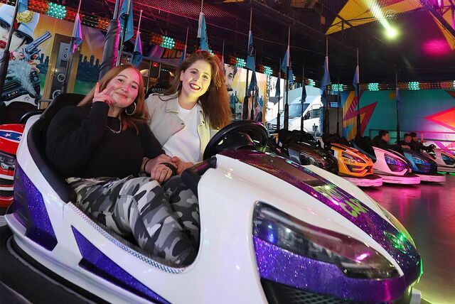 Zwei Mädchen sitzen bei der Katharinenkirmes in Unna im Autoscooter.
